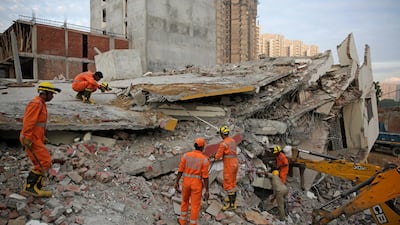 Rescuers search survivors at the site of a collapsed building. AP Photo