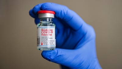Immunization Coordinator Laurie Cohen holds a vial of the Moderna Covid-19 vaccine in the Community Health Services building in Aspen, Colo. The Aspen Times via AP