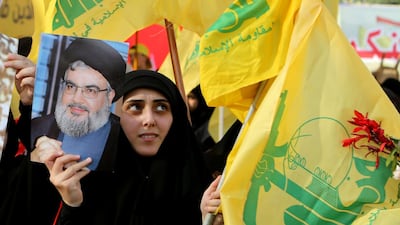 A supporter of Lebanon's Hezbollah leader Hassan Nasrallah holds a picture of him during a rally. REUTERS