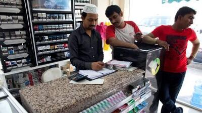 Manager Khatim Jibran (centre) at the Eid Grocery which was broken into. The shop's front window was smashed and the owner suffered losses of Dh3,000. Christopher Pike / The National