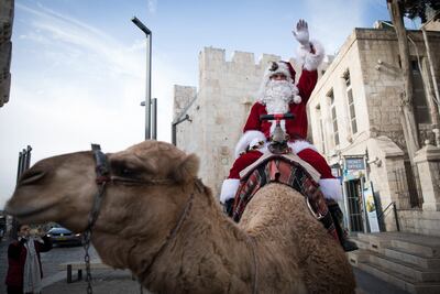 A Palestinian dressed in a Santa Claus costume next to the walls of Jerusalem's Old City. EPA