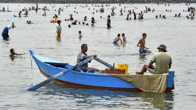 Temperatures in Tunisia have hovered around the 40°C over the past week. Here, a fisherman rows past people cooling off in the Mediterranean Sea at a beach off the northern town of La Goulette (Halq al-Wadi), 12 kilometres east of Tunis.