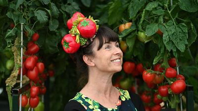 A woman wearing a tomato-themed hat poses for a photo. AFP
