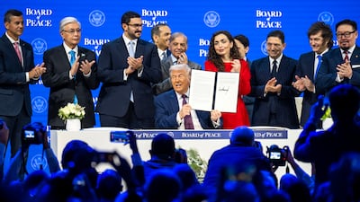 US President Donald Trump holds up the signed founding charter at the Board of Peace meeting. EPA