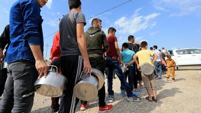 Syrian displaced families, who fled violence after the Turkish offensive in Syria, stand in queue to get their food from Barzani charity at a refugee camp in Bardarash on the outskirts of Dohuk, Iraq. Reuters