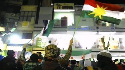 Demonstrators and wave a Kurd flag and pre-Baath Party Syrian flags during a protest against Syria's President Bashar Al Assad in Qudsaya, near Damascus.