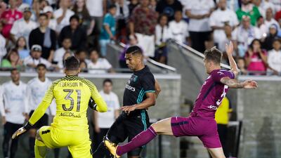 Real Madrid's Casemiro, centre, dribbles past Manchester City's John Stones, left. Jae C Hong / AP Photo