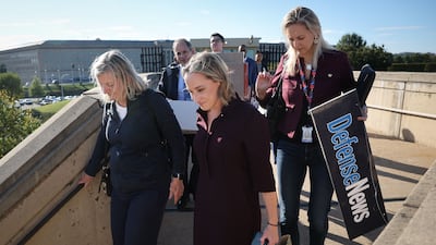 Pentagon reporters walk out of the building carrying their belongings after turning in their press badges. Getty Images / AFP