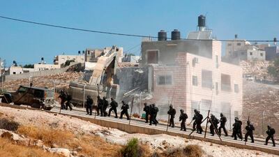 This picture taken from the West Bank on July 22, 2019 shows Israeli security forces tearing down one of the Palestinian buildings still under construction in the Wadi Al Hummus area adjacent to the Palestinian village of Sur Baher in occupied East Jerusalem. AFP