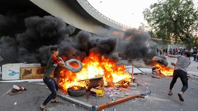 Demonstrators burn tires as they block the road in Baghdad. Reuters