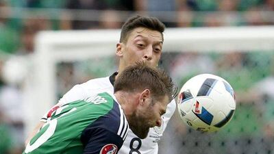 Northern Ireland's Oliver Norwood, left, and Germany's Mesut Ozil vie for the ball during the Euro 2016 Group C soccer match between Northern Ireland and Germany at the Parc des Princes stadium in Paris, France, Tuesday, June 21, 2016. (AP Photo/Michael Probst)