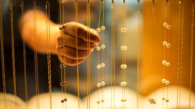 A seller puts pearl collars on display in his shop in Souq Waqif market, Doha, Qatar. AP Photo