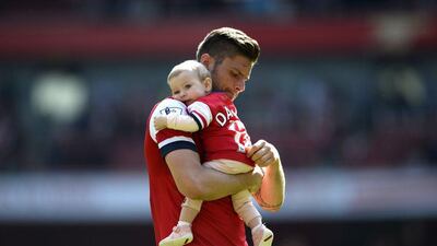Arsenal striker Olivier Giroud carries his daughter around the pitch after the club's Premier League victory on Sunday. Dylan Martinez / Reuters / May 4, 2014