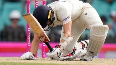 England's Mark Wood is knocked down by a yorker from Australia's Pat Cummins and is LBW during the fifth day of their Ashes cricket test match in Sydney, Sunday, Jan. 9, 2022. (AP Photo / Rick Rycroft)