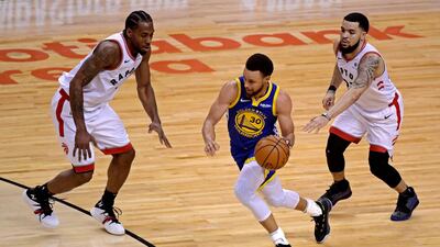 Golden State Warriors guard Stephen Curry, centre, drives to the basket against Toronto Raptors forward Kawhi Leonard (2) and guard Fred VanVleet (23). USA Today