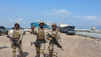 Soldiers of the Saudi-led coalition forces gesture as they guard ships docked in the southern Yemeni port of Aden on October 29, 2018. AFP