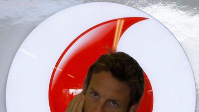 Jenson Button covers his ears inside his garage during the third practice session. Suhaib Salem/Reuters