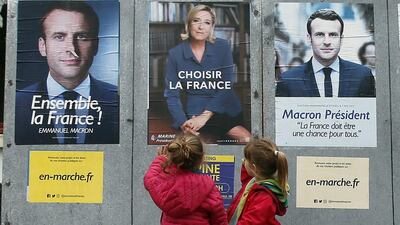 Children walk past election campaign posters for French centrist presidential candidate Emmanuel Macron and far-right candidate Marine Le Pen, in Osses, south-western France, on May 5, 2017. Bob Edme / AP Photo