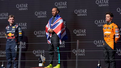 Mercedes driver Lewis Hamilton, centre, on the podium after winning the British Grand Prix, with second-placed Max Verstappen of Red Bull, left, and third-placed Lando Norris of McLaren. PA