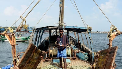 Indian fisherman Satish, 20, poses with his smartphone standing on a fishing vessel at Kasimedu fishing harbour in Chennai. AFPA