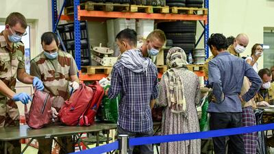 People have their luggage checked by soldiers. AFP