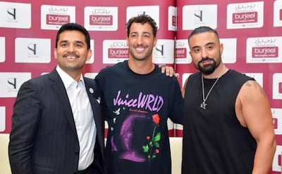 Daniel Ricciardo sports his new look alongside Dr Shamsheer Vayalil, chairman and managing director of VPS Healthcare and Kris Fade, Virgin Radio Dubai talk show host