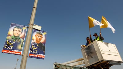 A worker prepares to hang Vatican flags ahead of Pope Francis's planned visit, in Najaf, Iraq. Reuters