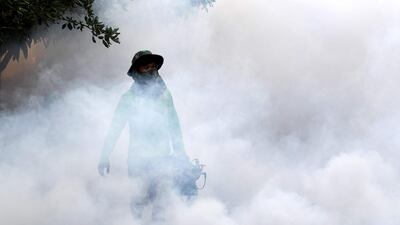 A man uses a mosquito fogging machine at a residential community in Phnom Penh. AFP