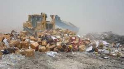 A bulldozer gets to work on the boxes of imitation vehicle spares seized during a raid in Sharjah.