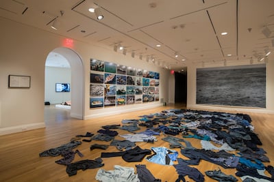 Installation view with Kader Attia's ominous sea of discarded blue clothing. Photo by Lee Stalsworth