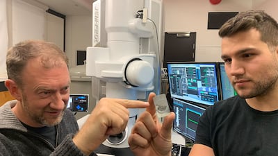 Monash University Professor Andy Tomkins, left, with Royal Melbourne Institute of Technology PhD student Alan Salek study a ureilite meteor sample at an RMIT facility in Melbourne, Australia. Photo: RMIT University
