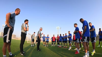UAE manager Bert van Marwijk speaks to the players during the training session.