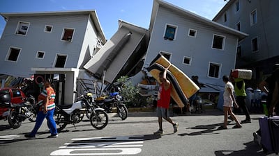Venezuelans carry their belongings through Catia La Mar, about 30km north-west of Caracas. AFP