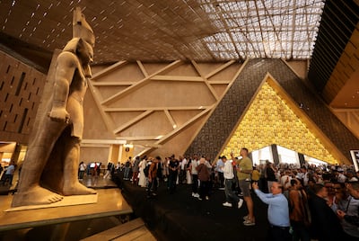 People walk in front of a statue of King Ramses II at the entrance of the Grand Egyptian Museum on Tuesday, the first day it was opened to the public. Reuters