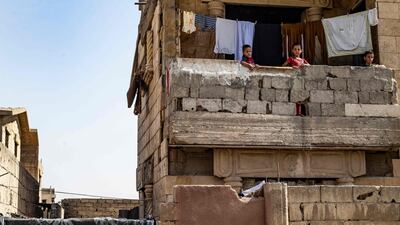 Syrian children, displaced with their family from Deir Ezzor, stand on the balcony of a damaged building where they are living in Syria's northern city of Raqqa.