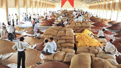 Indian farmers wait with their produce for the daily grain auction to begin at a wholesale market.