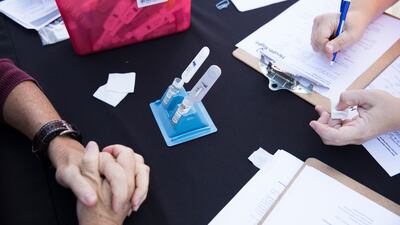 A patient fills out a form while her blood and saliva are screened for Hepatitis C and HIV in the US. Getty Images