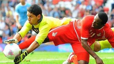 The UAE's Ahmed Khalil, right, gets into a tangle with Uruguay goalkeeper Martin Campana during their Olympic tie at Old Trafford. Andrew Yates / AFP