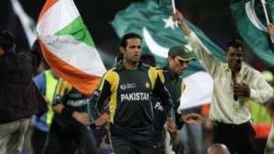 Pakistan's Rana Naveed , centre, and Younus Khan, behind, run after jubilant spectators invaded the pitch following their win against India.