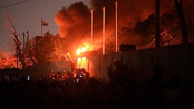 People burn the governor's building during protests in Basra. AP Photo