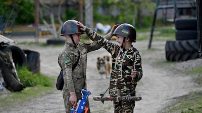Ukrainian boys play at being soldiers in the village of Stoyanka. AFP