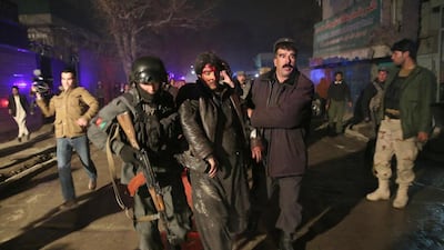 Afghan security forces assist an injured man after an attack on a Kabul restaurant popular with foreigners on January 17 in which 16 people were killed. Massoud Hossaini / AP Photo