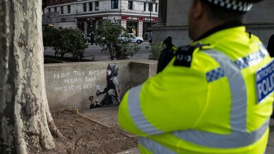 A police officer walks past the street art which is believed to be by Banksy. Getty Images