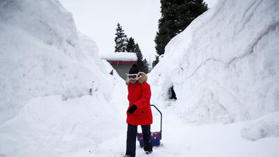 A resident at one of her properties buried in snow in California. The state's atmospheric river has caused snow, strong winds and flooding. EPA