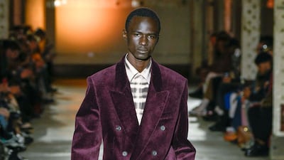 Wearing a burgundy velvet suit a model walks the runway at the Qasimi Autumn/Winter 2020 fashion show at London Fashion Week Men's. Getty Images