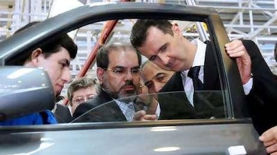 Syrian President Bashar Assad, right, inspects a car at the Syrian-Iranian Company for Manufacturing Cars in the industrial city of Adra near Damascus.