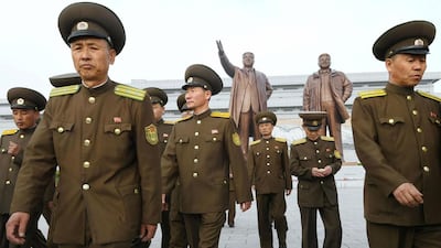 North Korean soldiers walk in front of bronze statues of North Korea's late founder Kim Il-sung and late leader Kim Jong Il at Mansudae in Pyongyang on April 25, 2017. Kyodo / via Reuters
