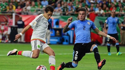 Mexico striker Javier Hernandez, left, moves the ball against Jose Gimenez of Uruguay. Jennifer Stewart / Getty Images