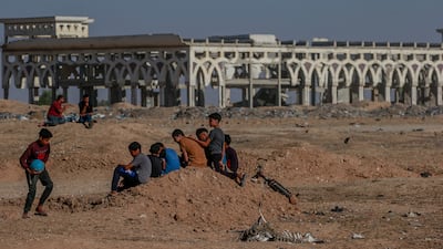 Youths play near a destroyed building on the grounds of the airport.