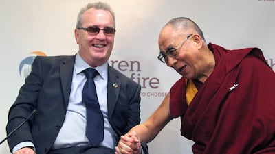 The Dalai Lama laughs with Richard Moore, director of Children in Crossfire, during a press conference in Londonderry, Northern Ireland, in April, 2013. AFP